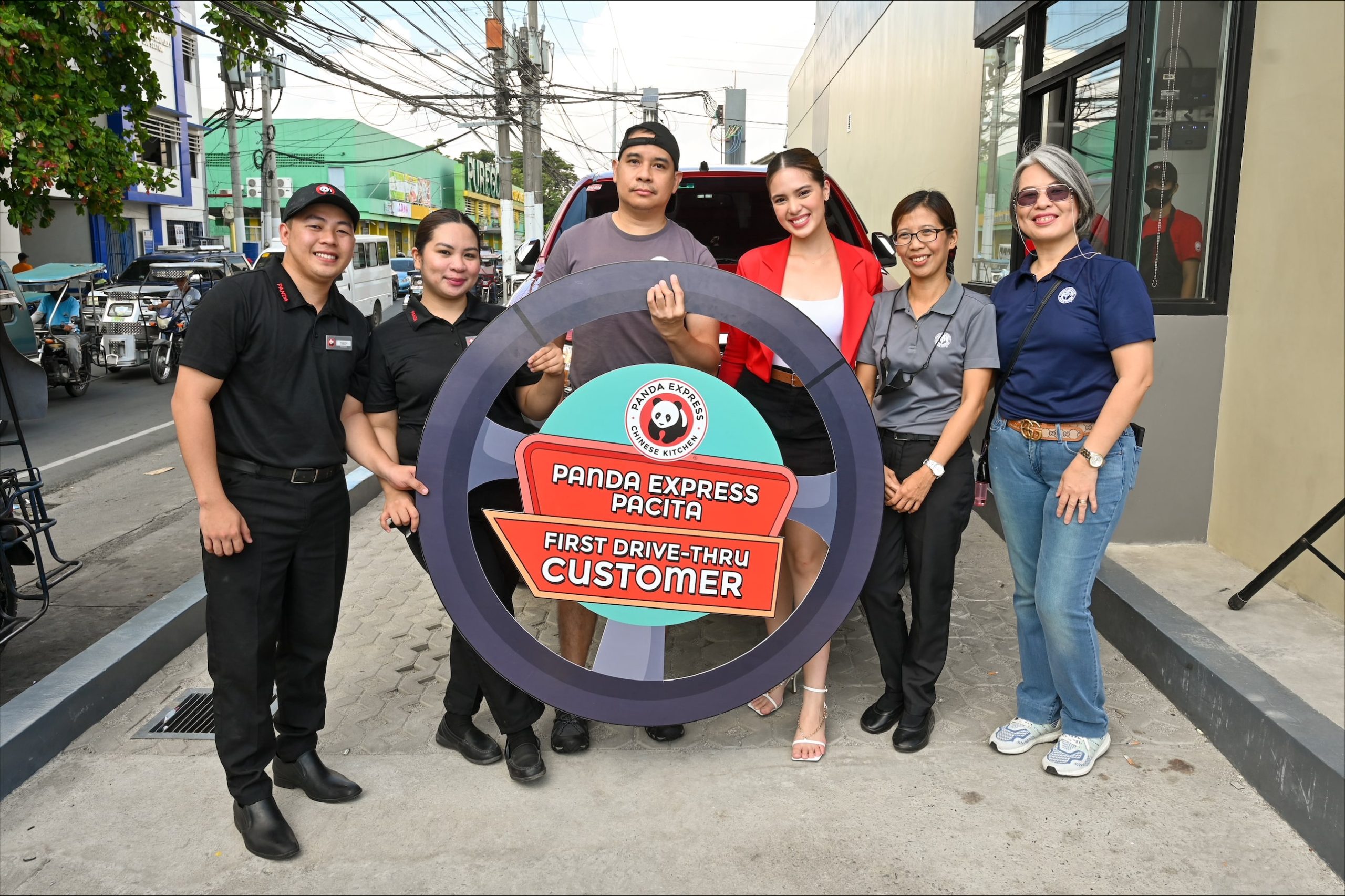Actress Michelle Vito (third from right), together with the Panda Express Philippines team, welcomed the store’s first drive-thru customer (center).